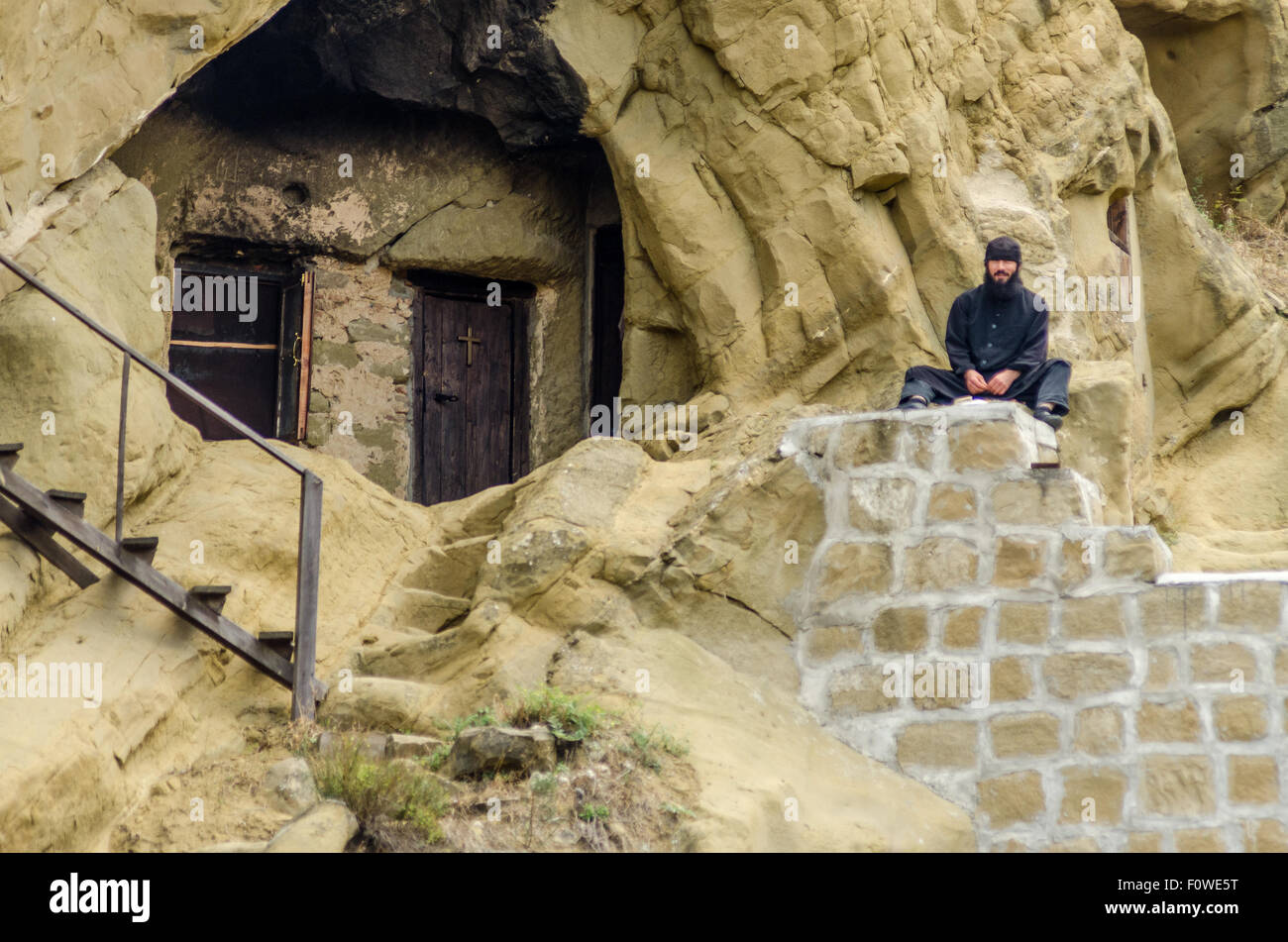 Einzigartige, in Felsen gehauene Wohnung mit Holzdeck in bergiger Landschaft zeigt alte architektonische Techniken Stockfoto