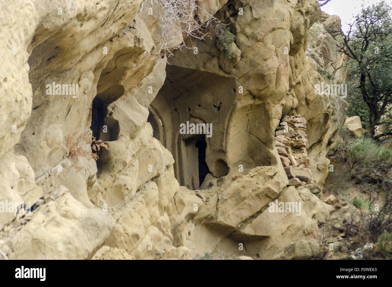 Einzigartige, in Felsen gehauene Wohnung mit Holzdeck in bergiger Landschaft zeigt alte architektonische Techniken Stockfoto