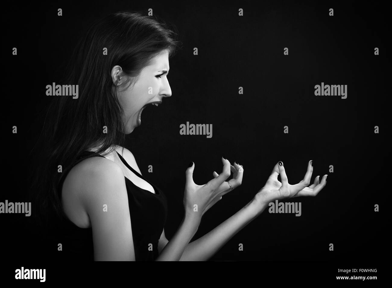 böse Frau schreit auf schwarzem Hintergrund monochromes Bild Stockfoto