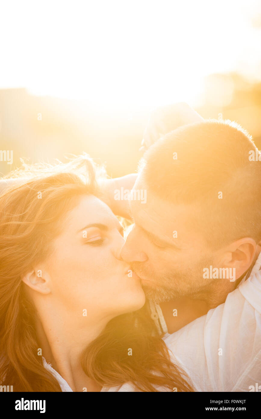 Paar küssen bei Sonnenuntergang - gegen die Sonne fotografiert Stockfoto