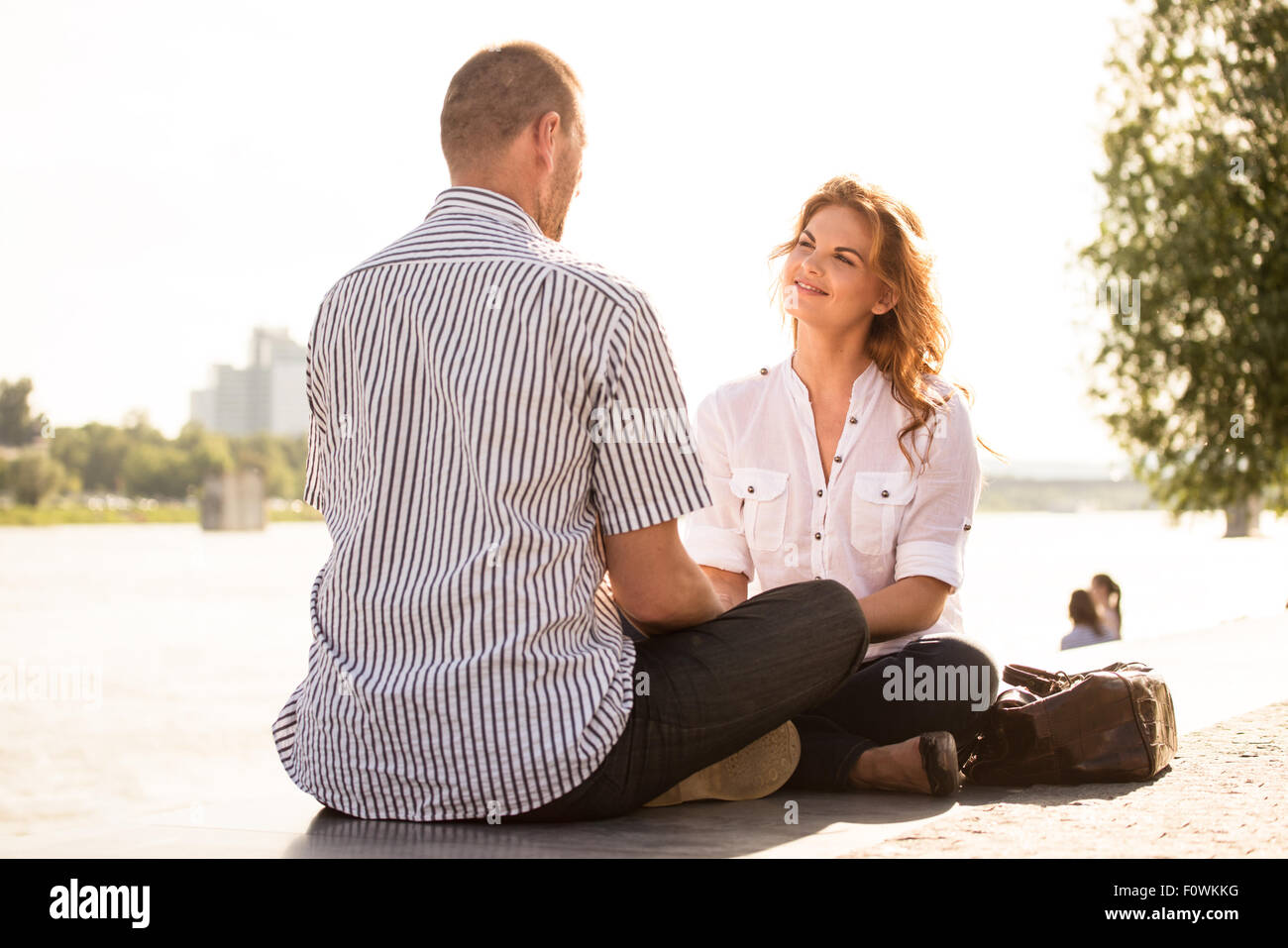 Junge Frau im Gespräch auf ein Date mit reifer Mann - sitzen im freien Stockfoto