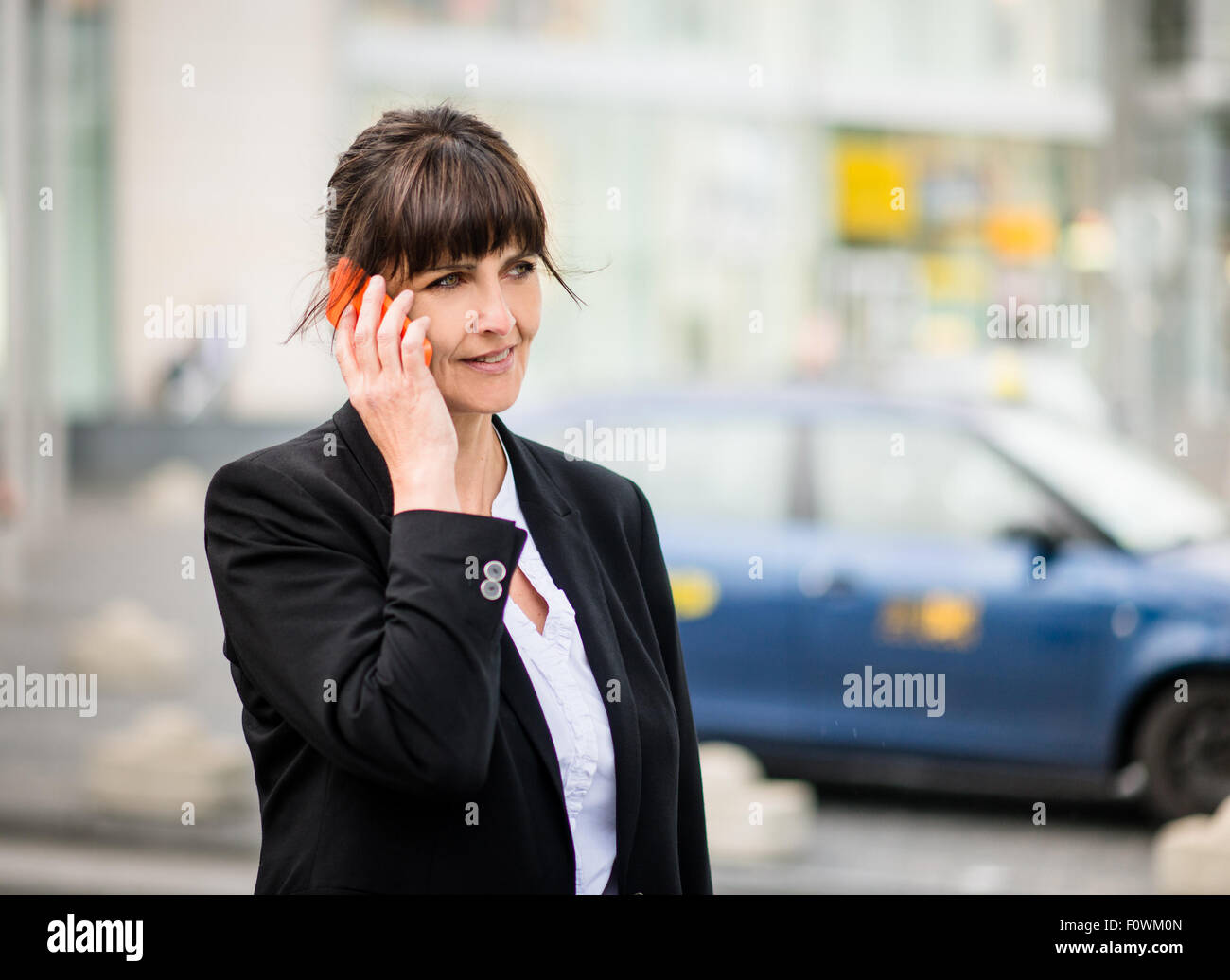 Senior Business-Frau mit ihrem Handy in der Straßenbahn im Hintergrund aufrufen Stockfoto