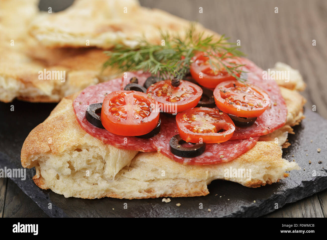 Sandwich mit Pita Brot Salami und Gemüse auf Holztisch Stockfoto