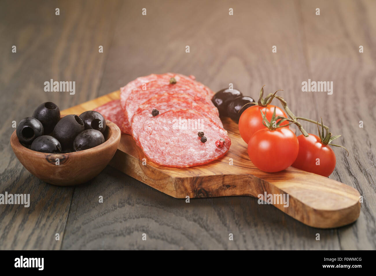 Antipasti mit Salami Oliven und Tomaten auf Holztisch Stockfoto