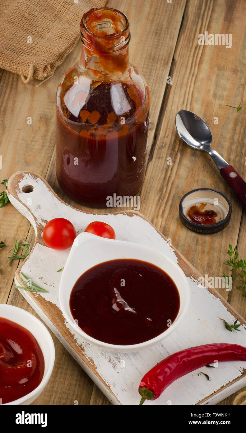Schalen mit Tomaten und Bbq-sauce auf einem Holztisch. Ansicht von oben Stockfoto