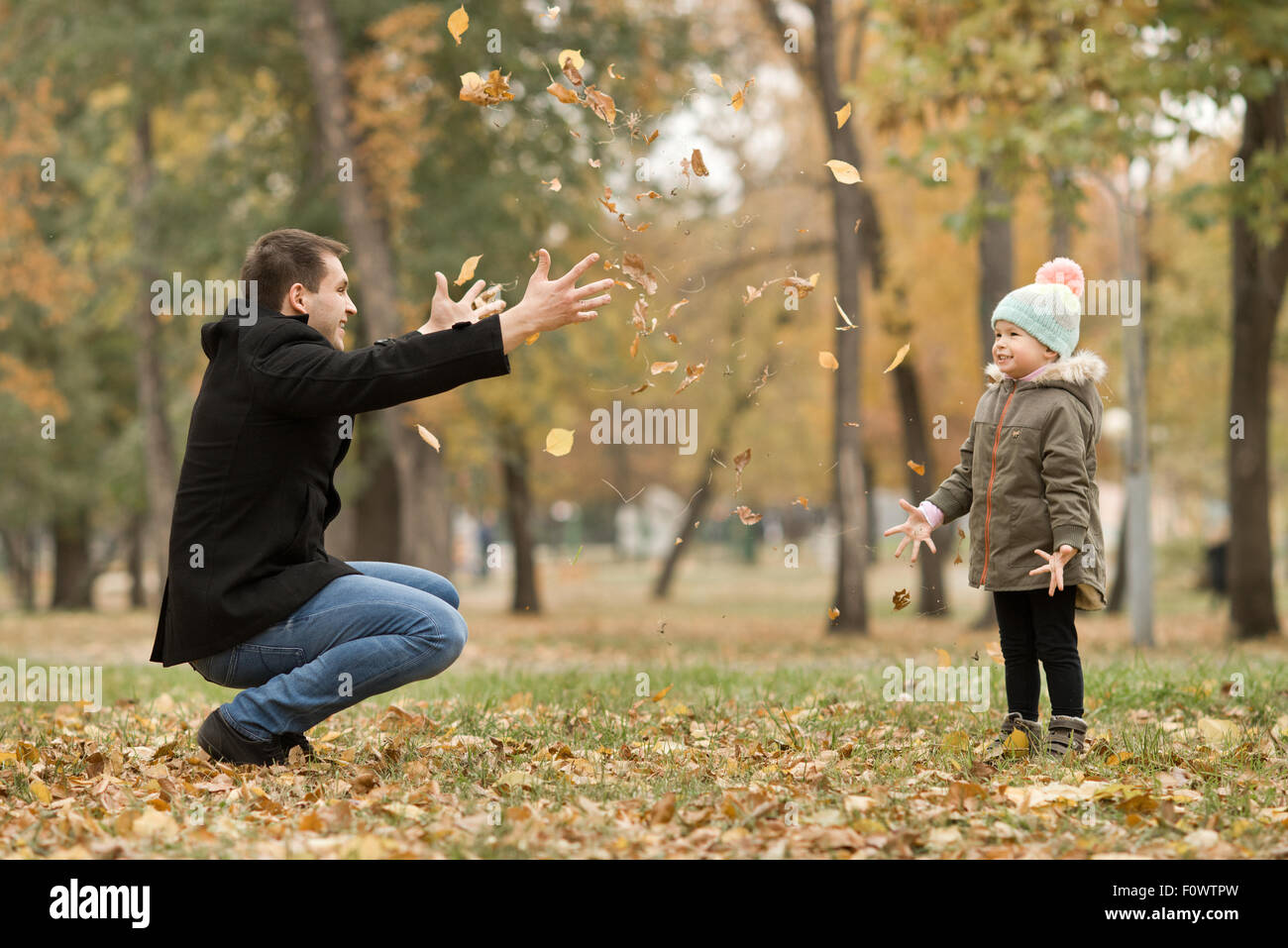 glücklicher Vater werfen kleine Kind mit Luftballons, Ausflug im Herbst park Stockfoto