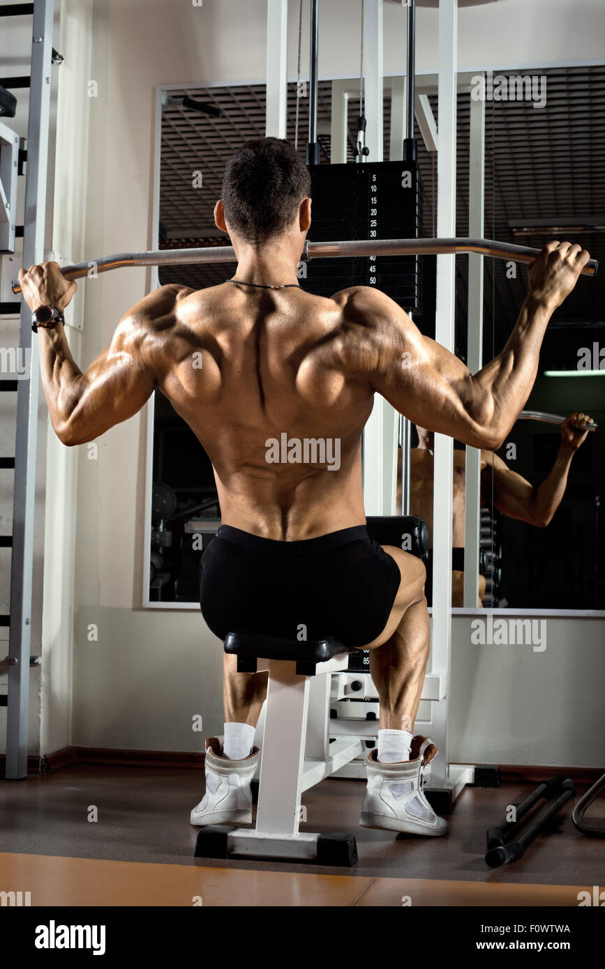 sehr athletischer Kerl Bodybuilder macht, Übung mit Fitness-Studio, am weitesten Muskeln der Rückseite ausführen Stockfoto