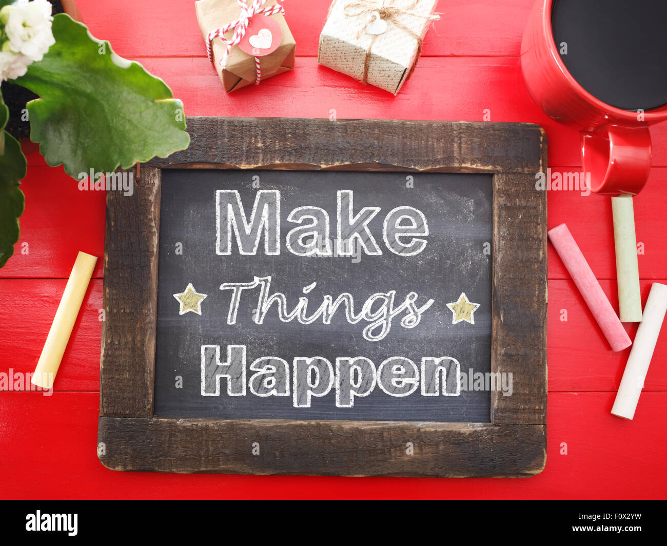Machen Sie Dinge passieren Nachricht auf einer Vintage Kreidetafel auf einem roten Tisch schriftliche Stockfoto