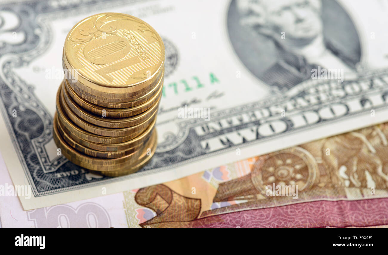 Haufen von Russen Münzen auf amerikanische Dollar-Schein Stockfoto
