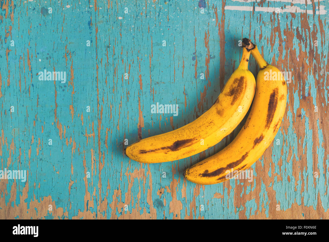 Zwei alte reife Bananen auf rustikalen Holztisch, Ansicht von oben Stockfoto