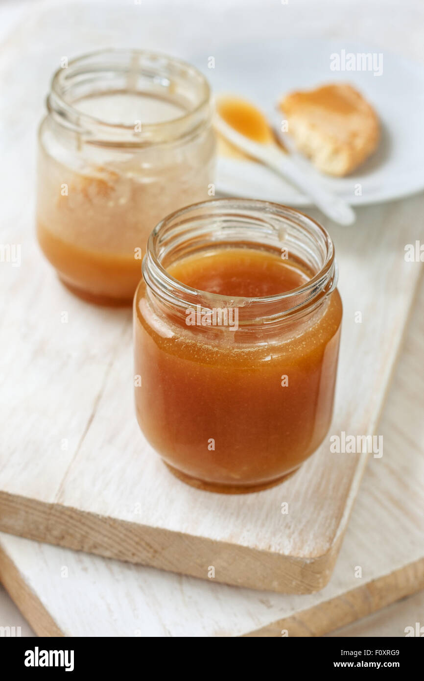 Karamell-Sauce in ein Glas auf einem hölzernen Hintergrund Stockfoto