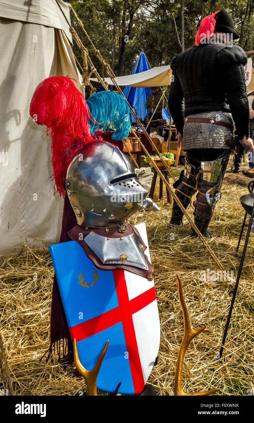 Eine Nahaufnahme eines mittelalterlichen Helmes mit einem Mann in einem Anzug der Rüstung im Hintergrund an der Abtei Mittelalterfest in Australien Stockfoto