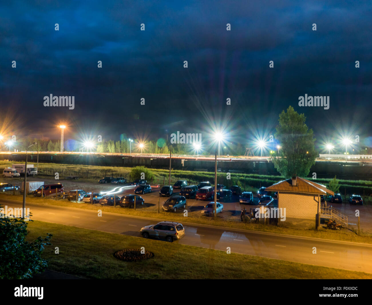 Parkplatz in der Nacht mit Straßenlaternen und erstaunlich dunkle Wolken Stockfoto