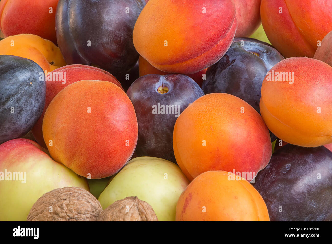 Spätsommer oder Herbst Obst Hintergrund, Pflaumen, Aprikosen, Äpfel. Stockfoto
