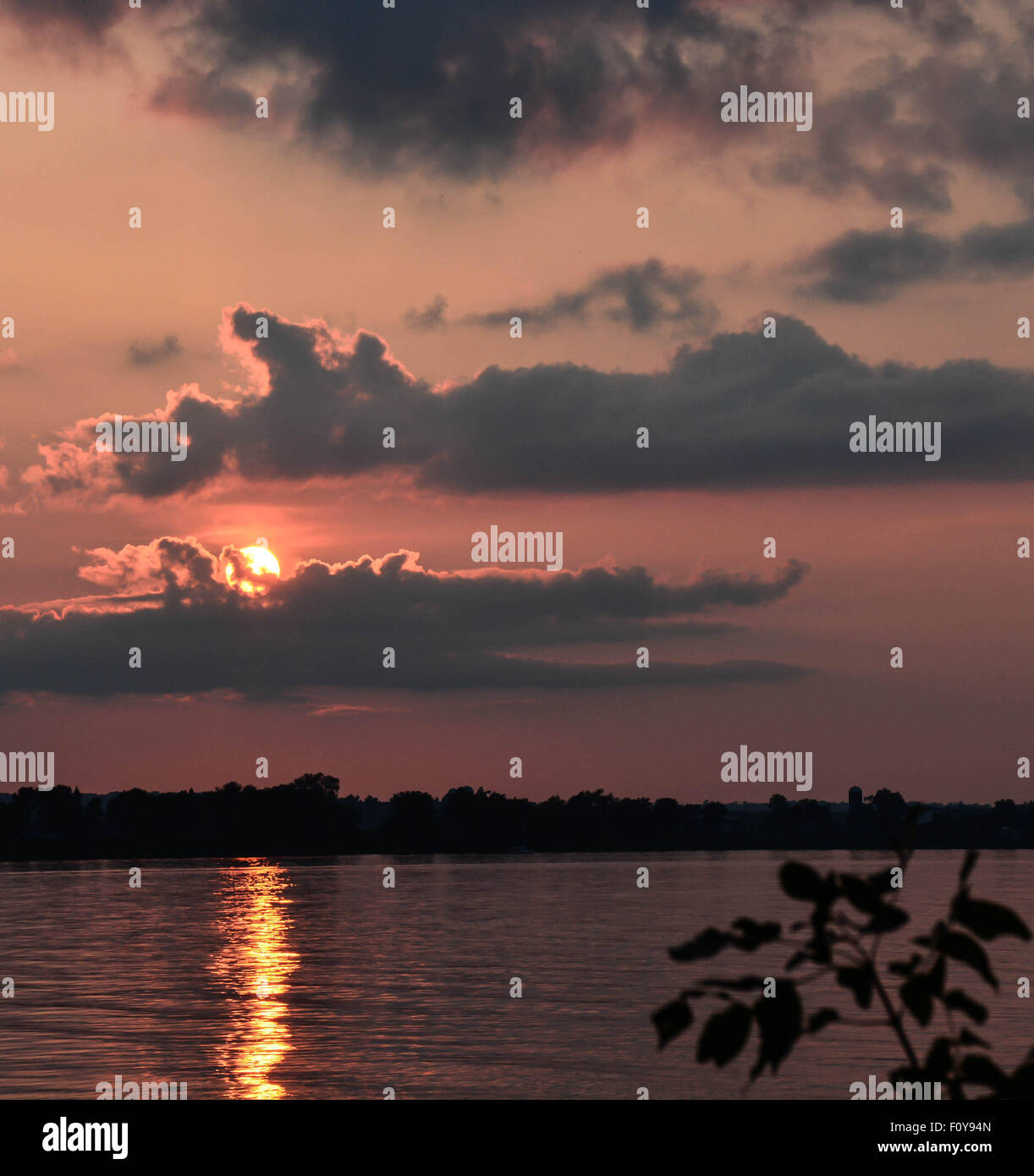 Sonnenuntergang über bewölktem Himmel über einem nördlichen See Stockfoto