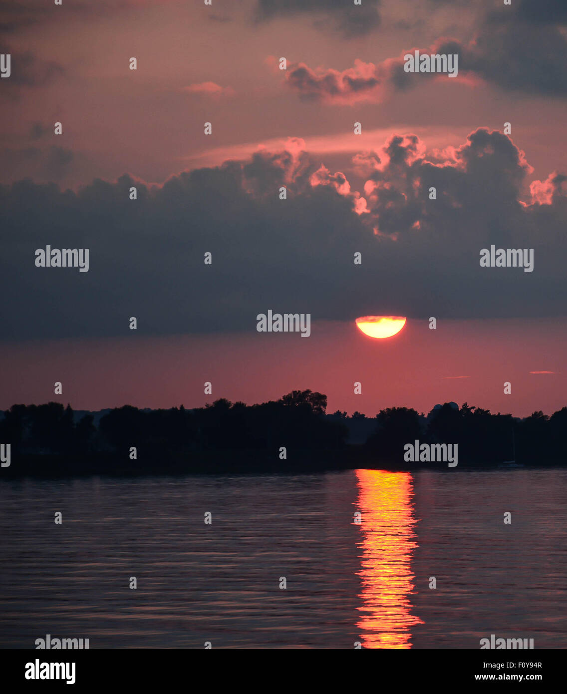 Sonnenuntergang über bewölktem Himmel über einem nördlichen See Stockfoto