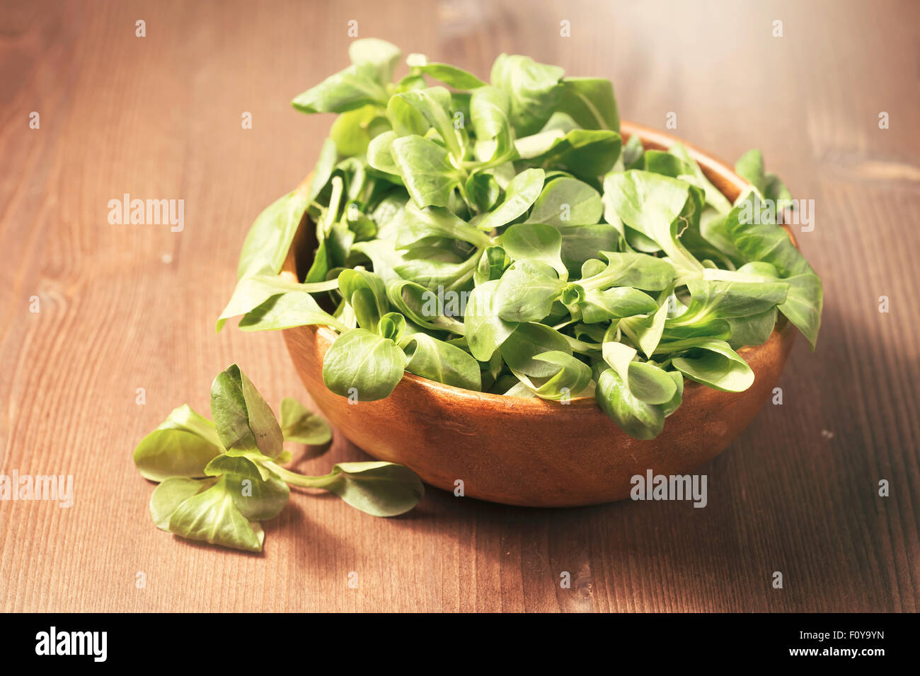Frischer Feldsalat in einer Holzschale auf hölzernen Hintergrund Stockfoto