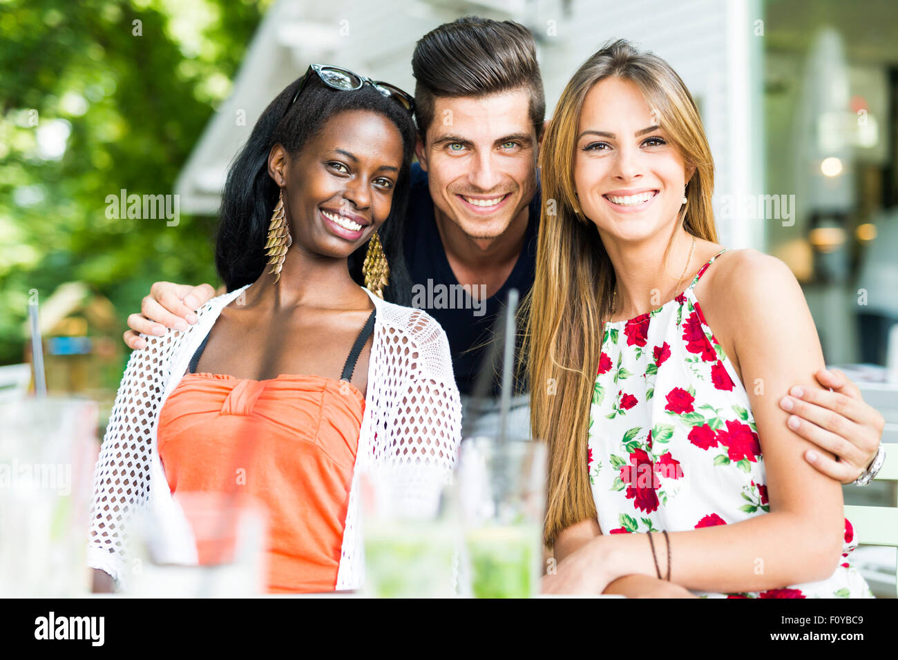 Glückliche junge Freunde lächelnd im Freien wird nah beieinander an einem Sommertag Stockfoto