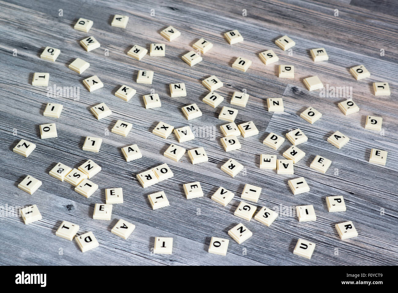 Kunststoff Buchstabensteine verstreut auf Holzboden Stockfoto