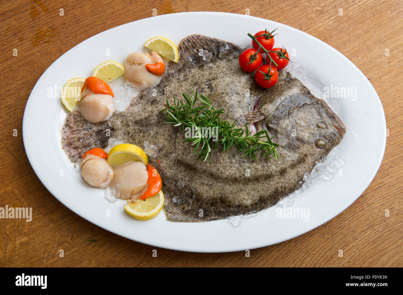 Ungekocht ganze Steinbutt mit Jakobsmuscheln und Cherry-Tomaten Stockfoto