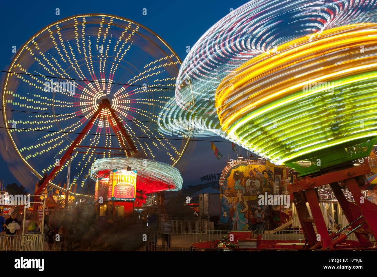 Bunt beleuchtete Fahrgeschäfte drehen gegen den Nachthimmel während der New Jersey State Fair in Augusta im US-Bundesstaat New Jersey. Stockfoto
