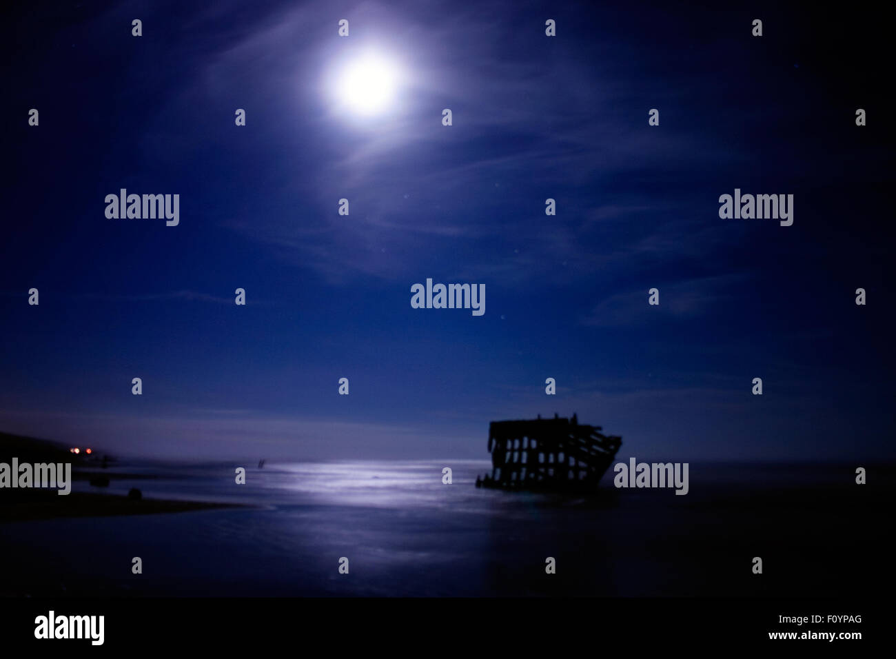Das Schiffswrack von Peter Iredale bleibt in der nebligen Nacht an der Pazifikküste durch das Mondlicht akzentuiert Stockfoto