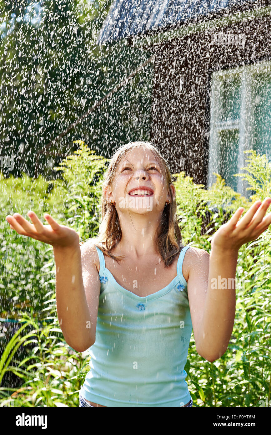 Glückliches Mädchen unter Sommerregen Stockfoto
