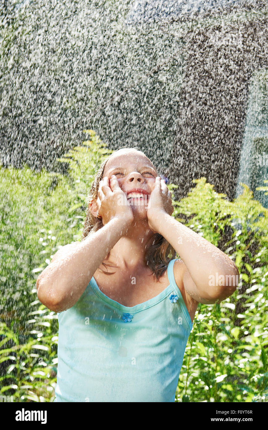 Glückliches Mädchen unter Sommerregen Stockfoto