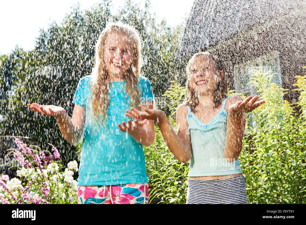 Zwei glückliche Mädchen unter Sommerregen Stockfoto