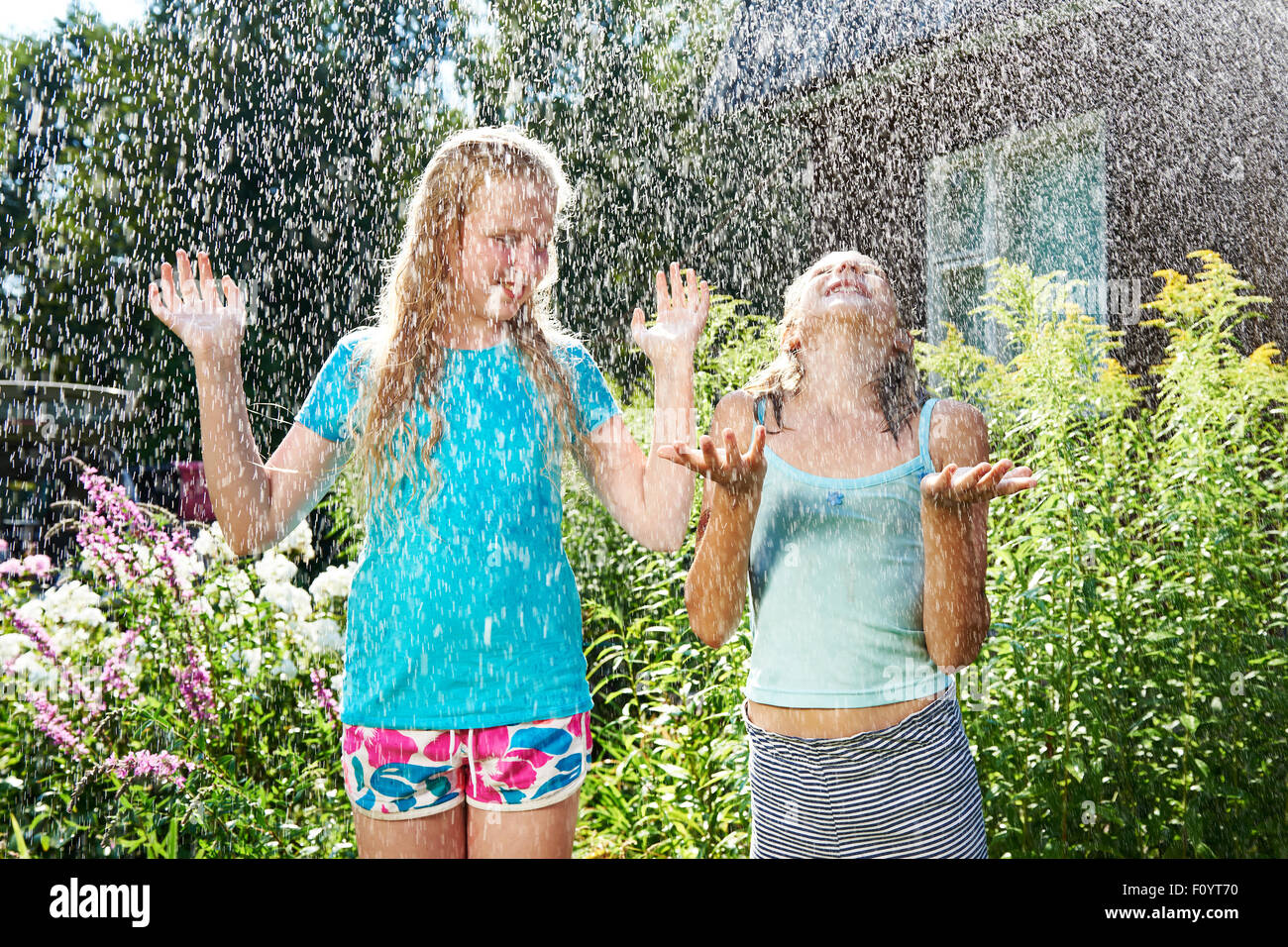 Zwei glückliche Mädchen unter Sommerregen Stockfoto