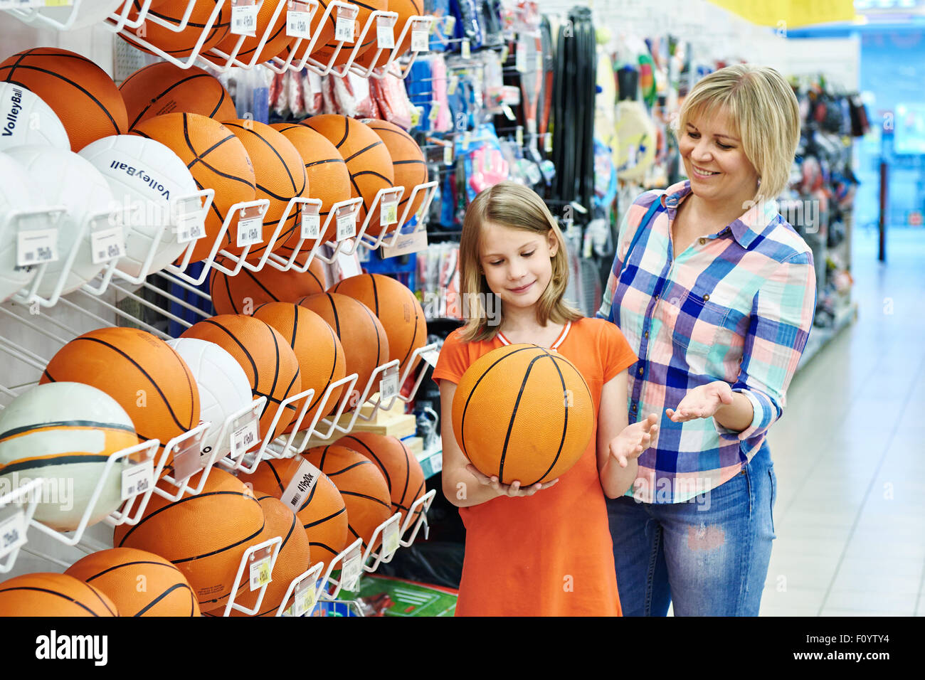 Mutter und Tochter einkaufen Basketball Ball im Sportgeschäft Stockfoto