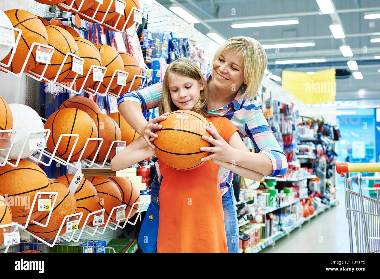 Mutter und Tochter einkaufen Basketball Ball im Sportgeschäft Stockfoto