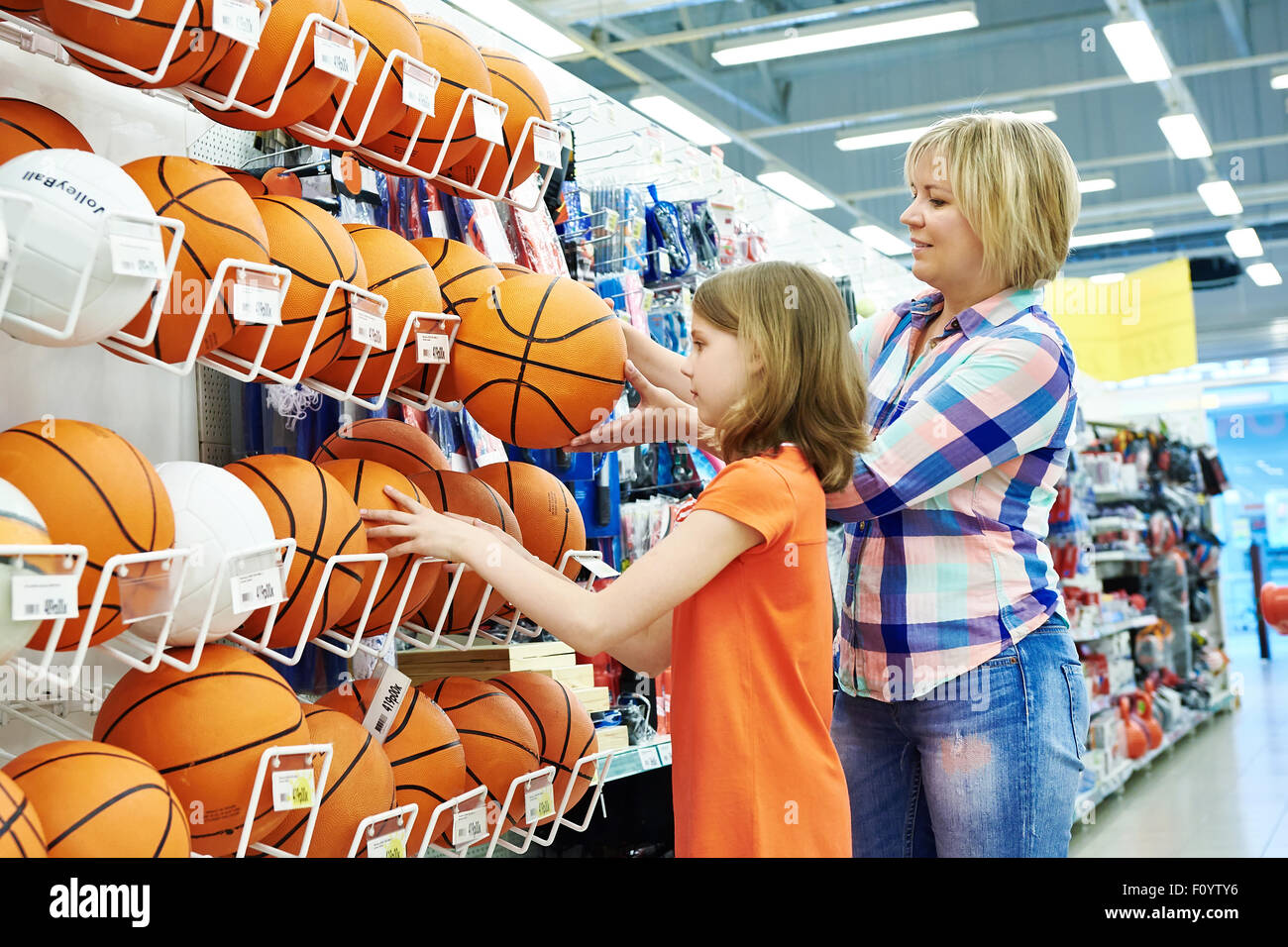 Mutter und Tochter einkaufen Basketball Ball im Sportgeschäft Stockfoto