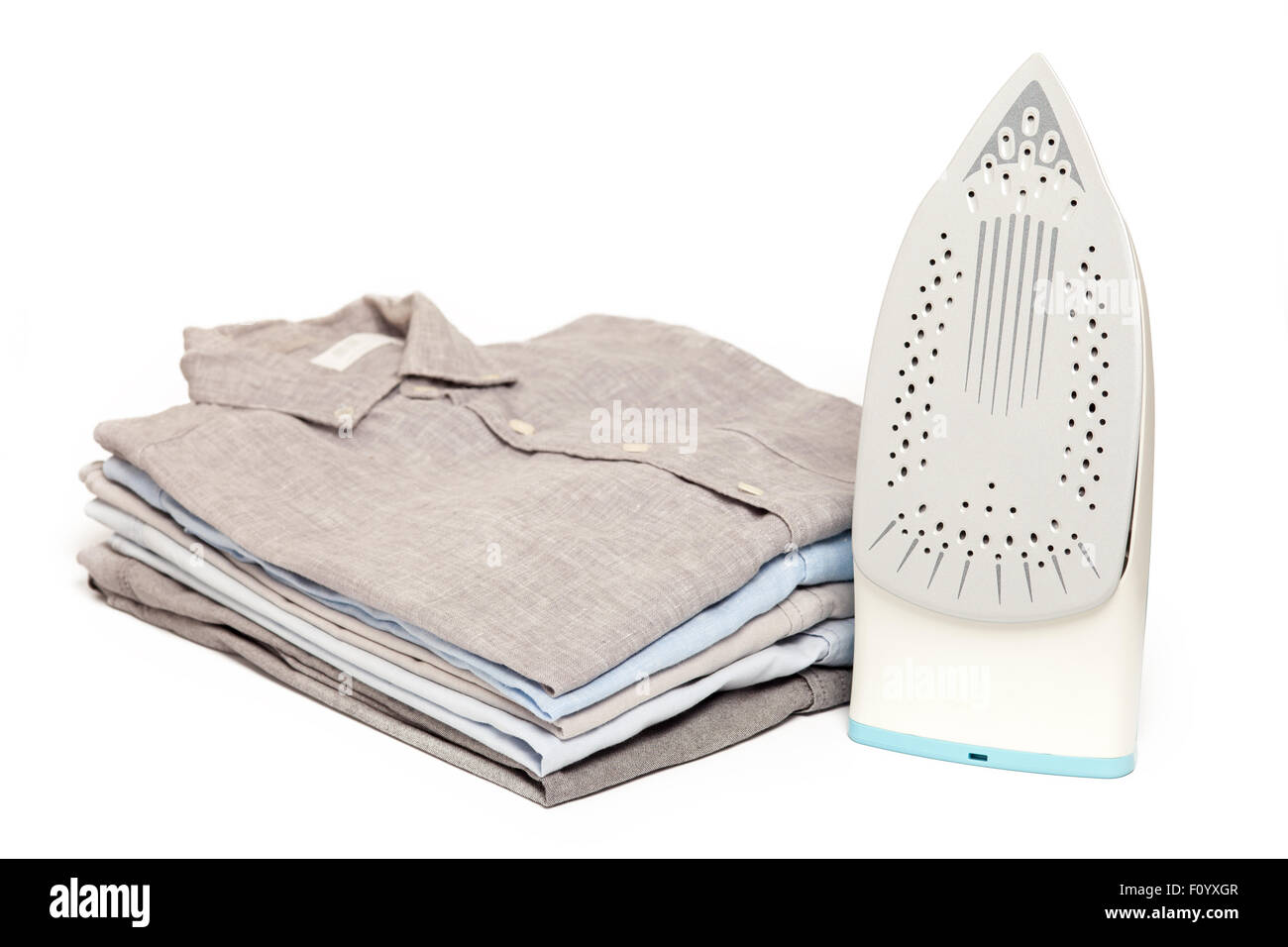 ein Bügeleisen/-Brett Hausarbeit gebügelt gefaltete Hemden sauber Konzept Stillleben Kleidungsstück Bekleidung Stoff innen weißer Hintergrund Stockfoto