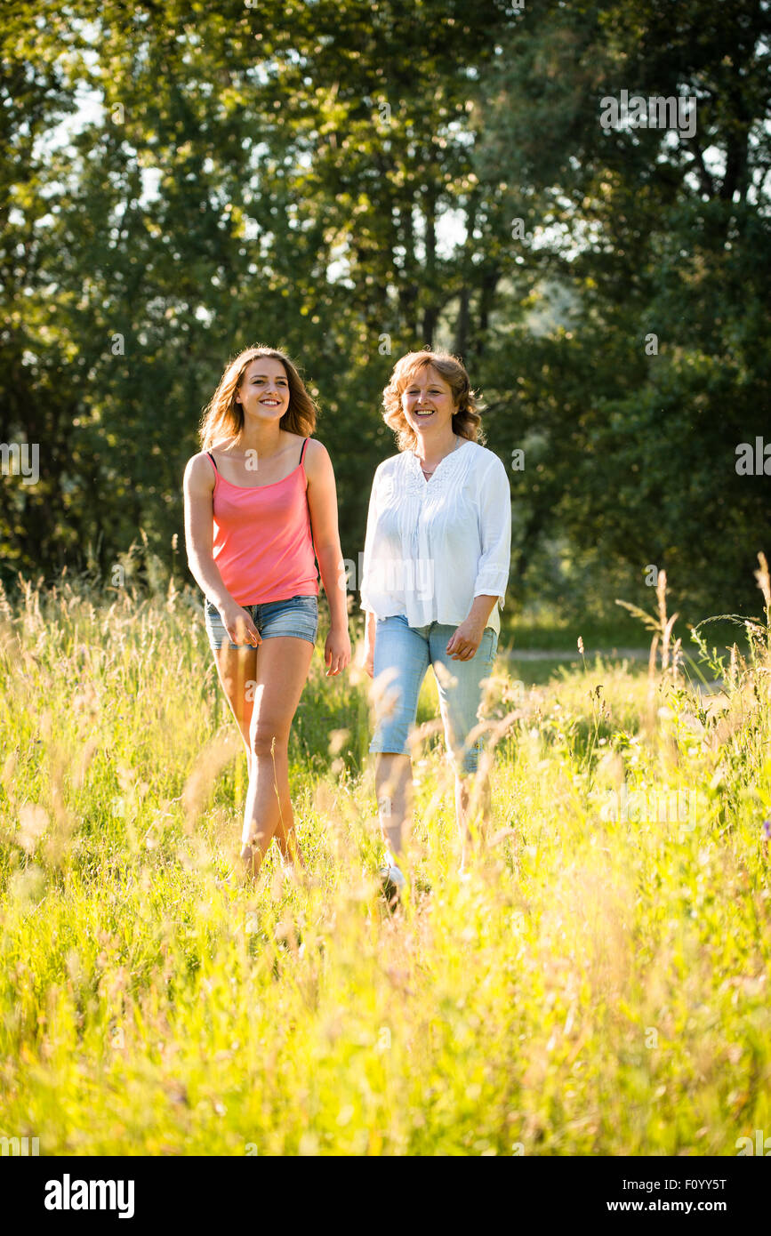 Reife Frau und ihre Tochter im Teenageralter zusammen spazieren in der Natur an sonnigen Sommertag im freien Stockfoto