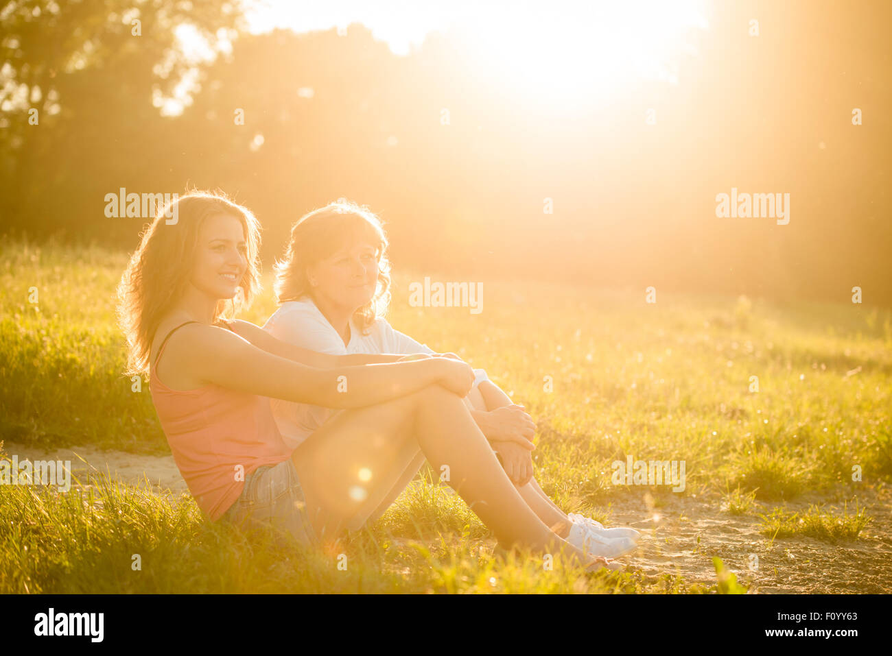 Reife Mutter mit ihrer Tochter am Ufer sitzen und tolle Zeit zusammen Stockfoto