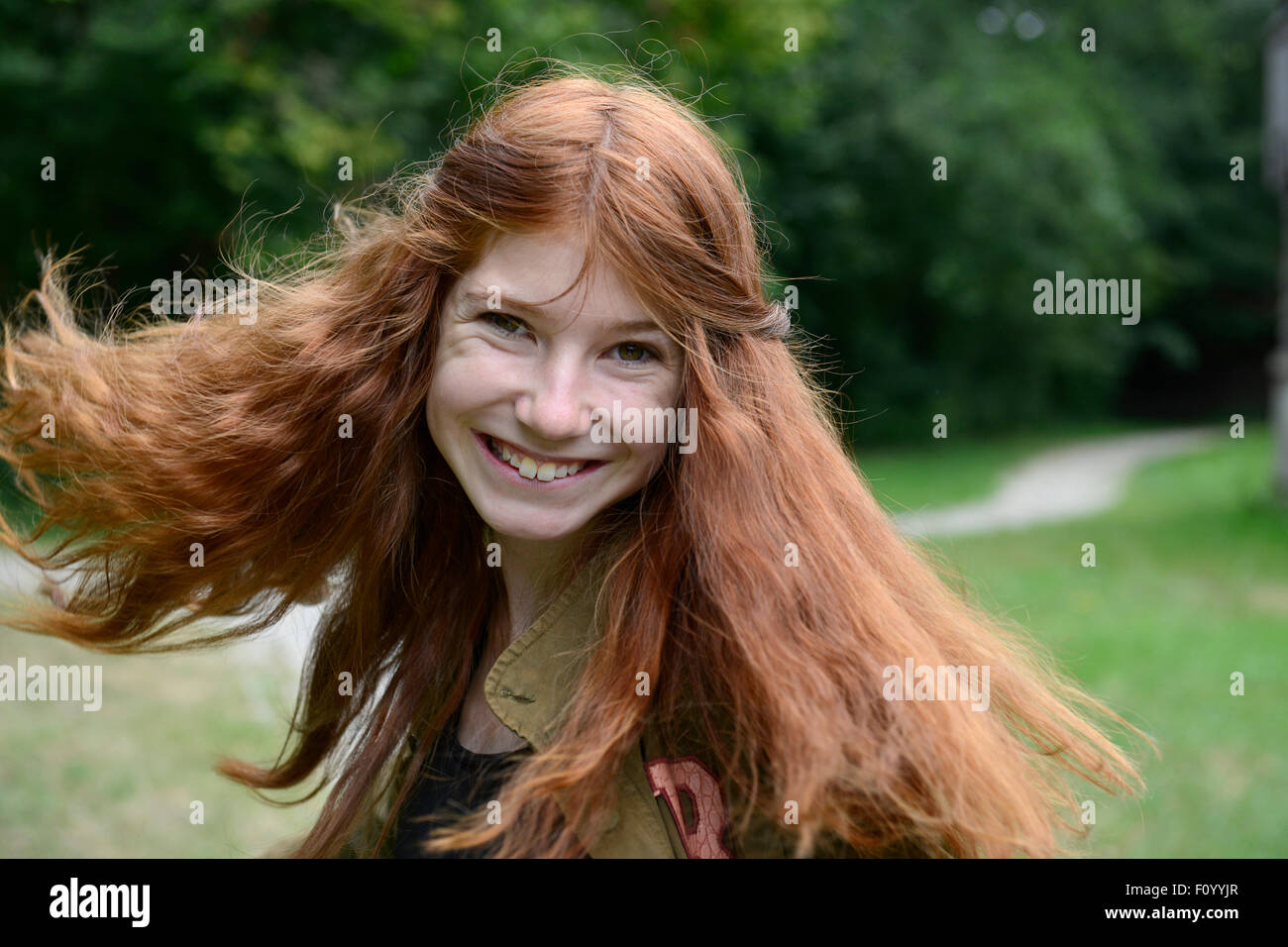 Teenager-Mädchen mit langen roten Haaren, streichen ihr Haar, Deutschland Stockfoto