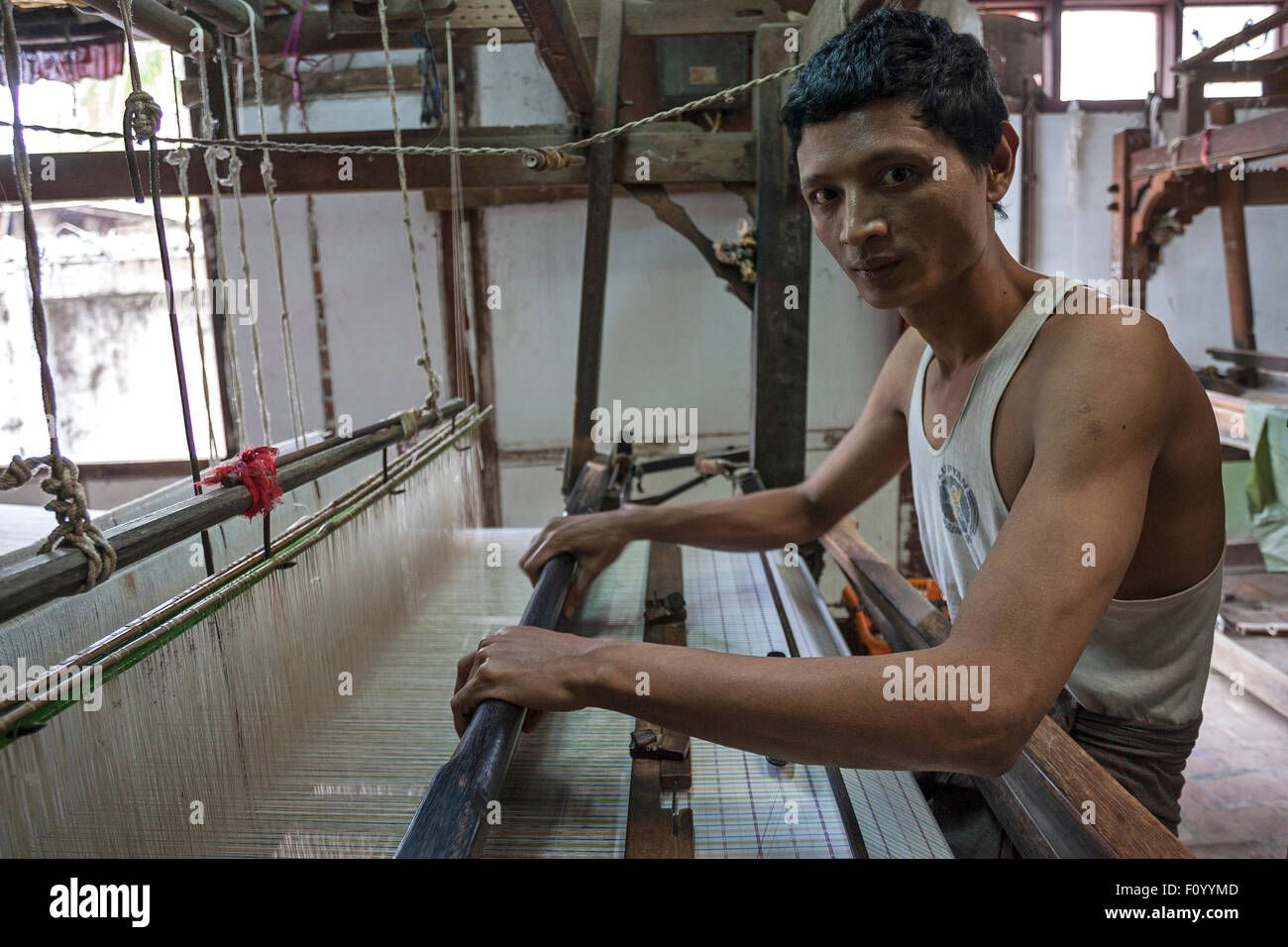 Lokale Mann arbeitet auf einem Webstuhl, Stoff-Weberei, Amarapura, Mandalay, Myanmar Divison Stockfoto