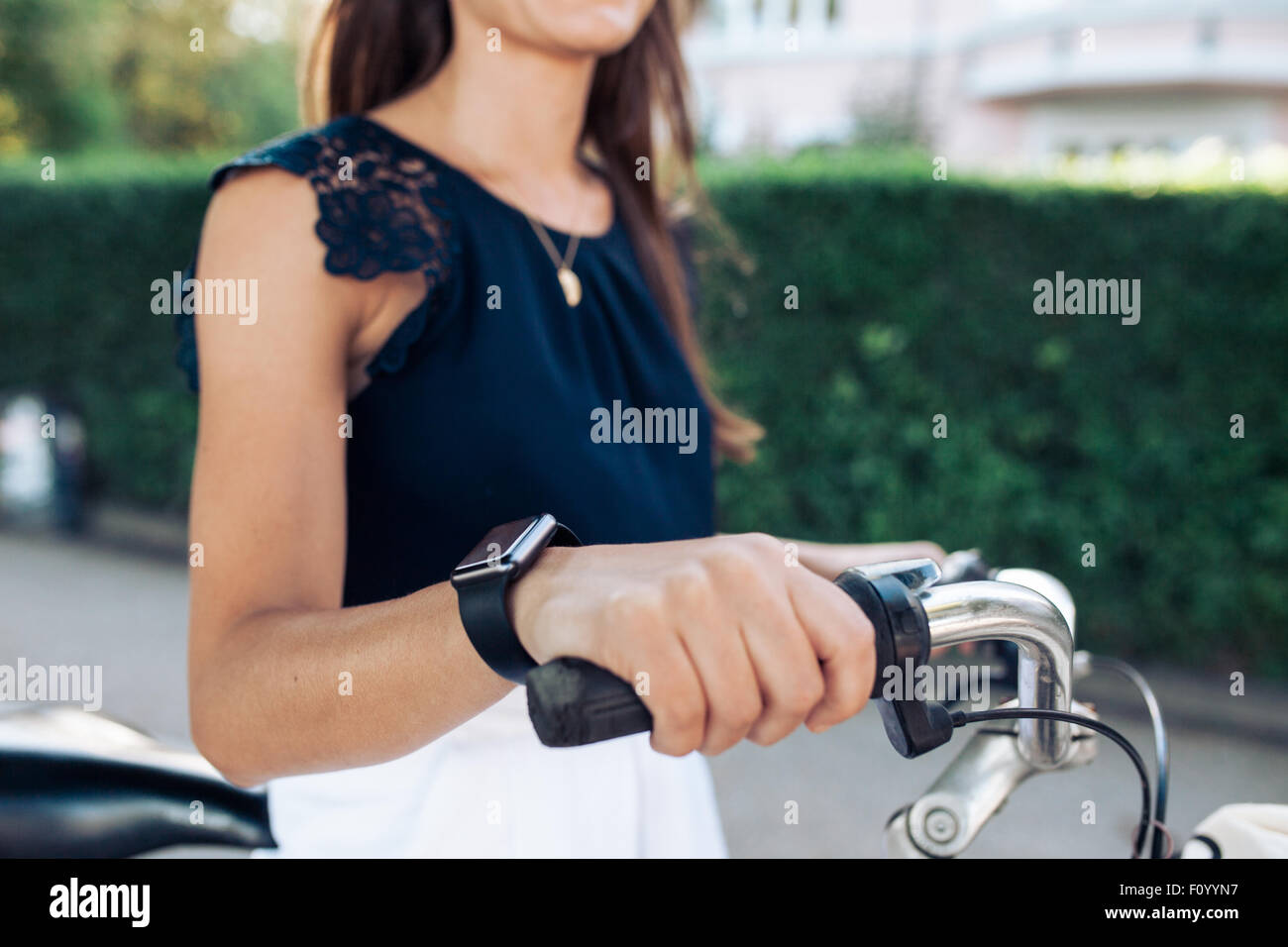 Frau mit dem Fahrrad mit einer Smartwatch. Weibchen tragen Smartwatch beim Radfahren. Stockfoto