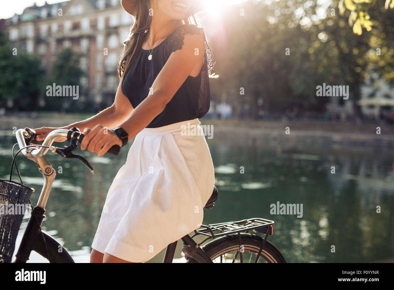 Aufnahme der jungen Frau an einem Teich Radfahren zugeschnitten. Frau an einem Sommertag mit ihrem Fahrrad. Stockfoto