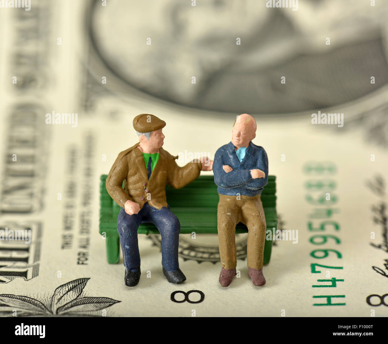 Rentner auf einer Bank, Dollarnote hinter symbolisches Bild für Rente, private und staatliche Rente Stockfoto