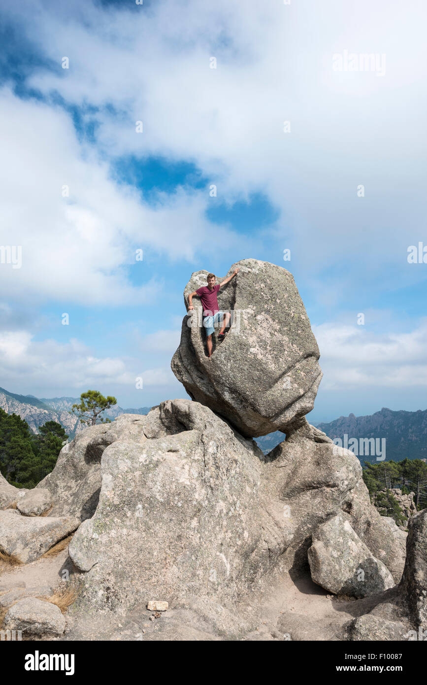 Junger Mann stehend in einer Felsformation Berg Landschaft, L'Ospedale Alta Rocca, Korsika, Frankreich Stockfoto