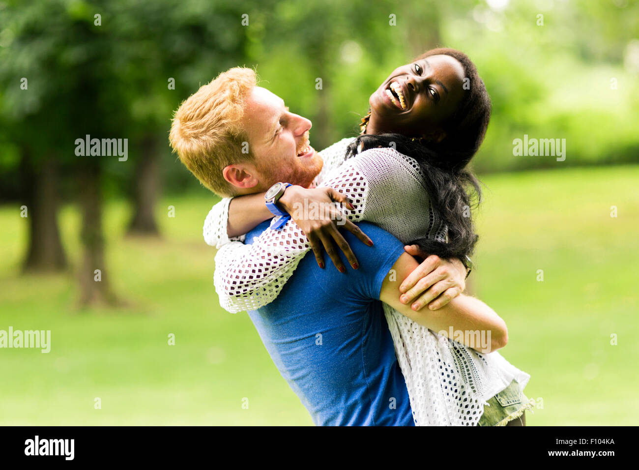 Porträt von einem glücklichen paar tanzen und umarmt in einem Park im freien Stockfoto