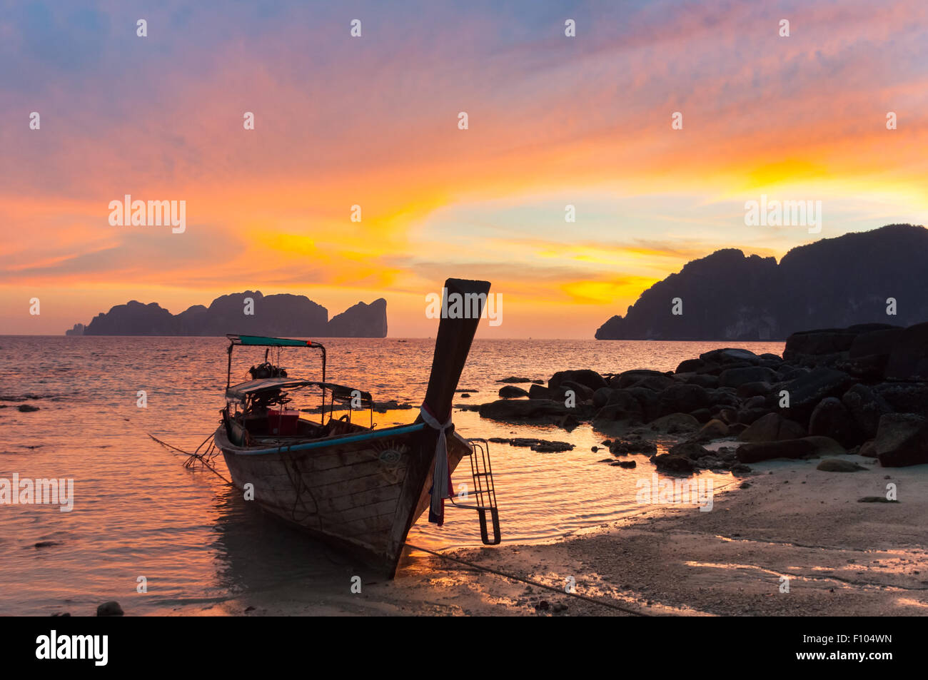 Traditionelle hölzerne Longtail-Boot am Strand im Sonnenuntergang, Thailand. Stockfoto