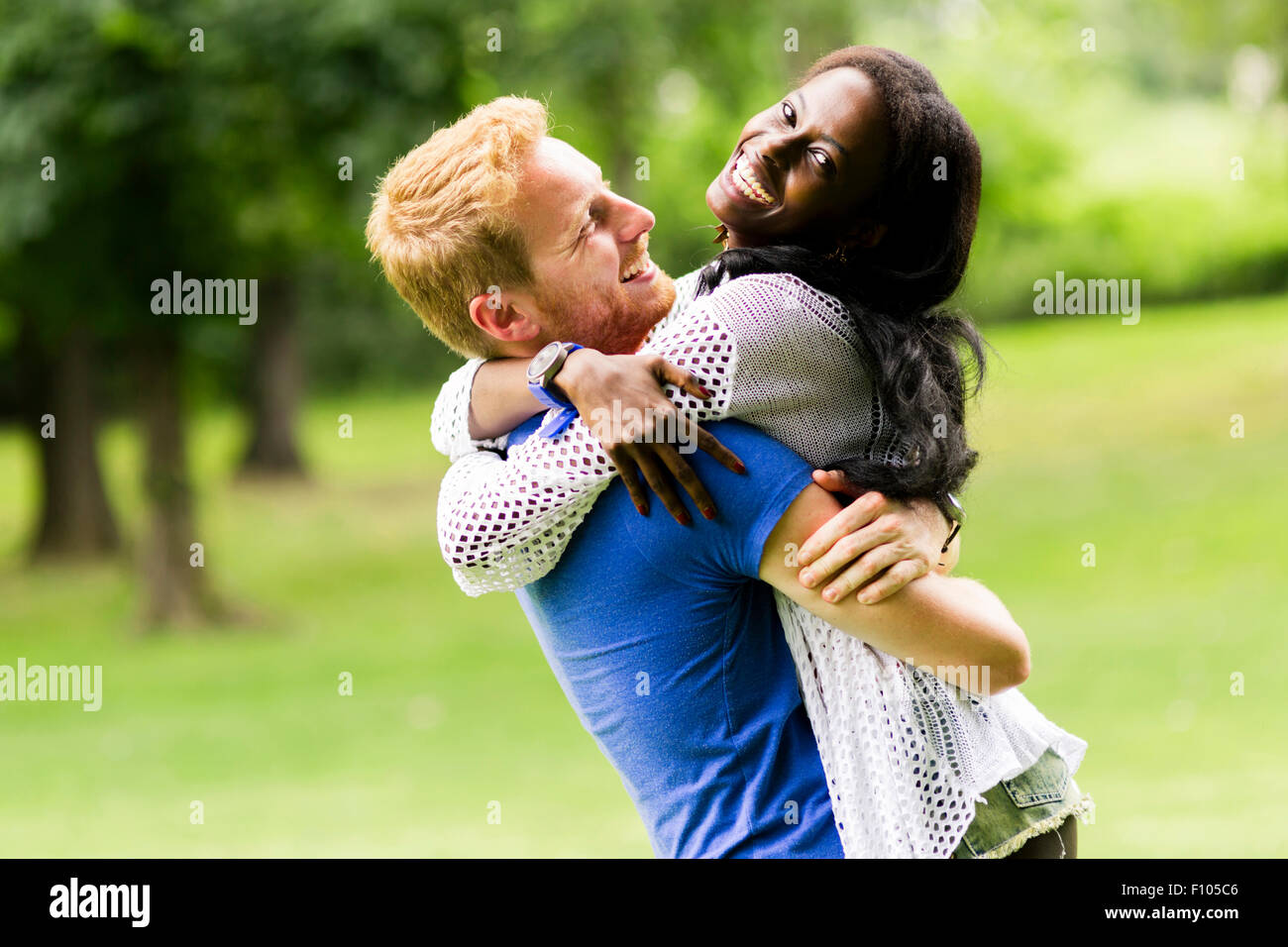 Porträt von einem glücklichen paar tanzen und umarmt in einem Park im freien Stockfoto