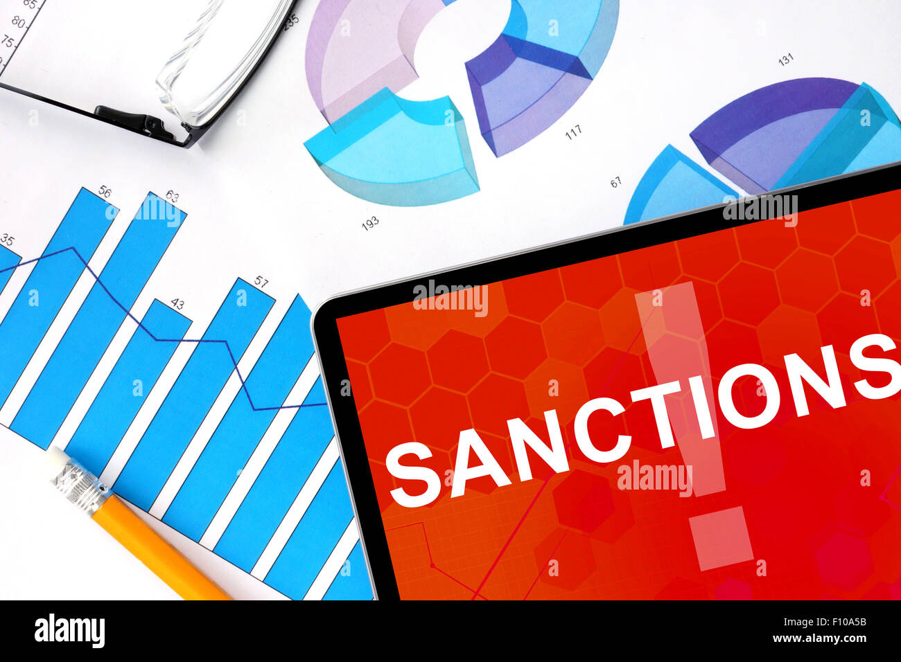 Tablet mit Wort Sanktionen und Grafiken. Konzept-Foto. Stockfoto