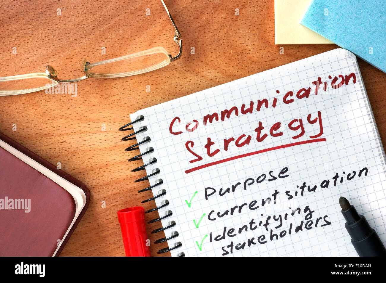 Notizblock mit Kommunikations-Strategie-Konzept auf einem Holzbrett. Stockfoto