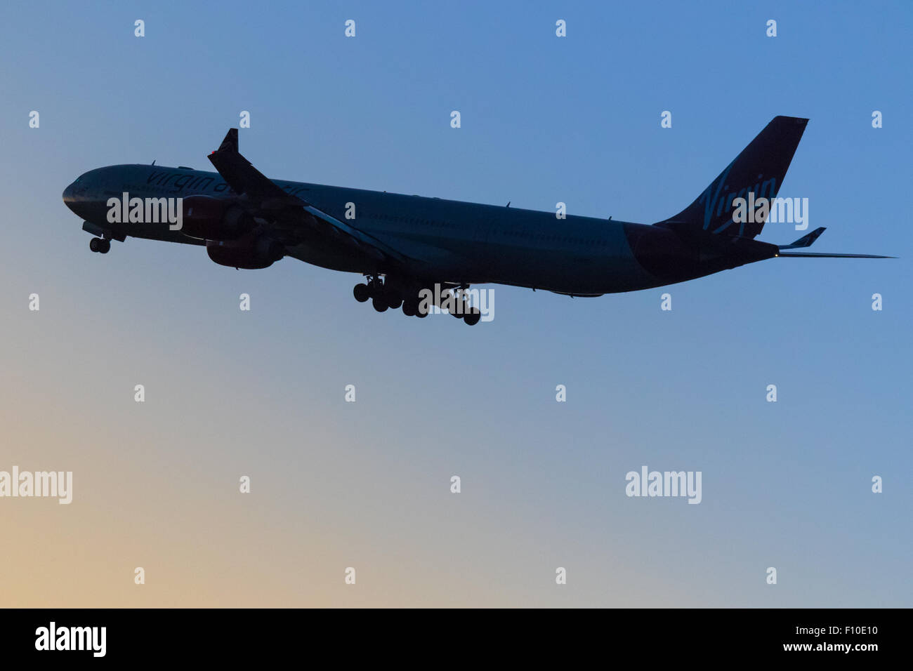 Eine Virgin Atlantic Airbus A340-600 fährt ab London Heathrow Start-und Landebahn 27L in einer dunkler werdenden Himmel. Stockfoto