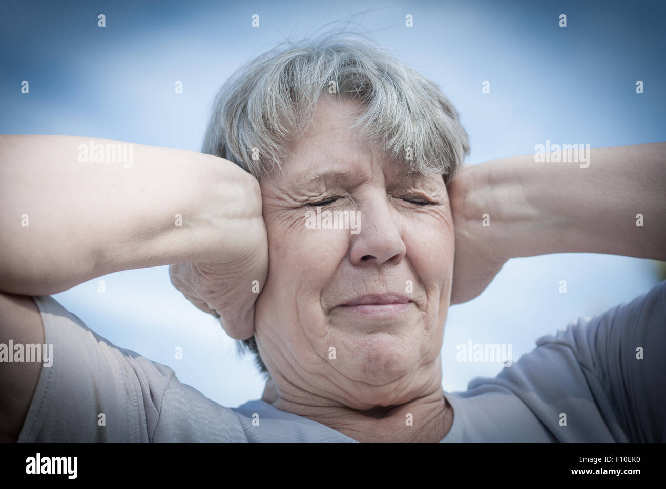 Alter Frau halten ihre Ohren geschlossen Stockfoto