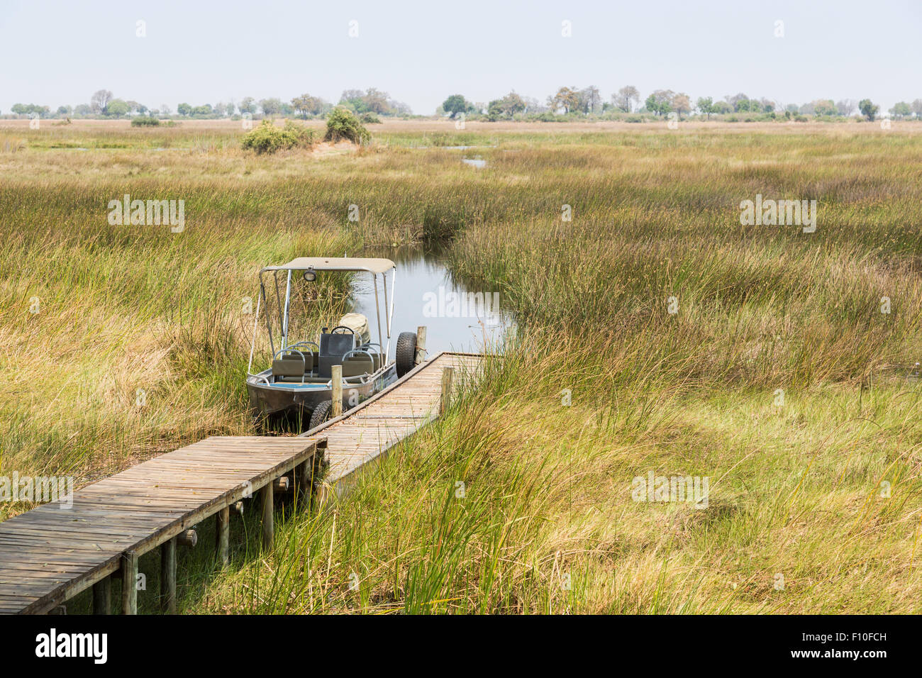 Safari-Motorboot vertäut am Steg in Bereitschaft für eine Flussfahrt für sightseeing, Duba Plains Camp Okavango Delta, Nord-Botswana, Südafrika Stockfoto
